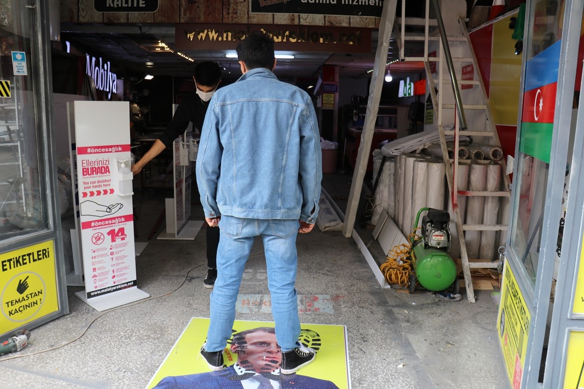 Macron’un portresini yere yapıştırdı: Fotoğrafa basmak için geliyorlar